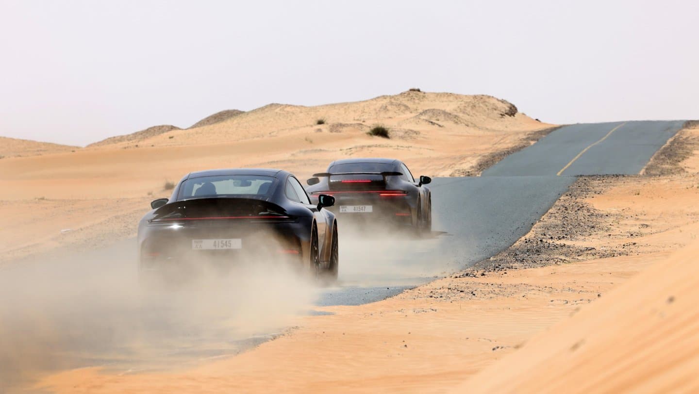 2025 Porsche 911 driving on desert road.