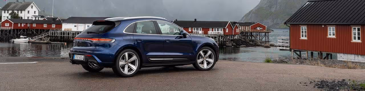 New Dark Blue Porsche Macan parked at a pier on a cloudy day